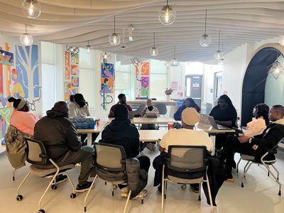 Group meeting in a modern, colorful room with hanging lights.