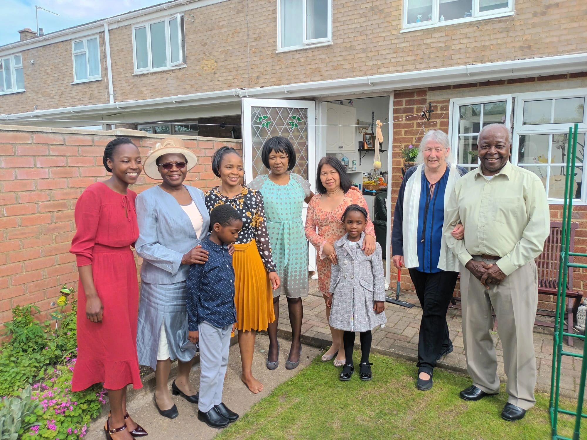 A multigenerational family smiling in a garden.