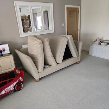 Beige couch with cushions flipped upright.