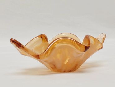 A decorative amber-colored glass bowl with wavy edges.
