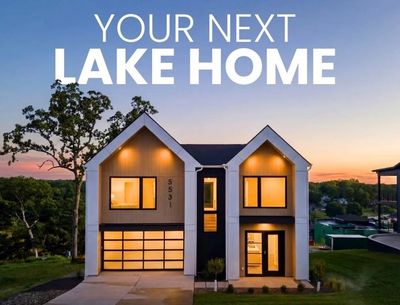 Modern lake house at sunset with large windows.