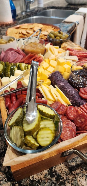 A vibrant charcuterie board with pickles, cheeses, meats, and crackers.