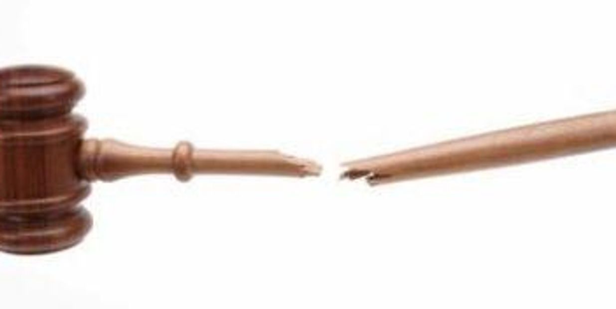 A broken wooden gavel handle split into two pieces on a white background.