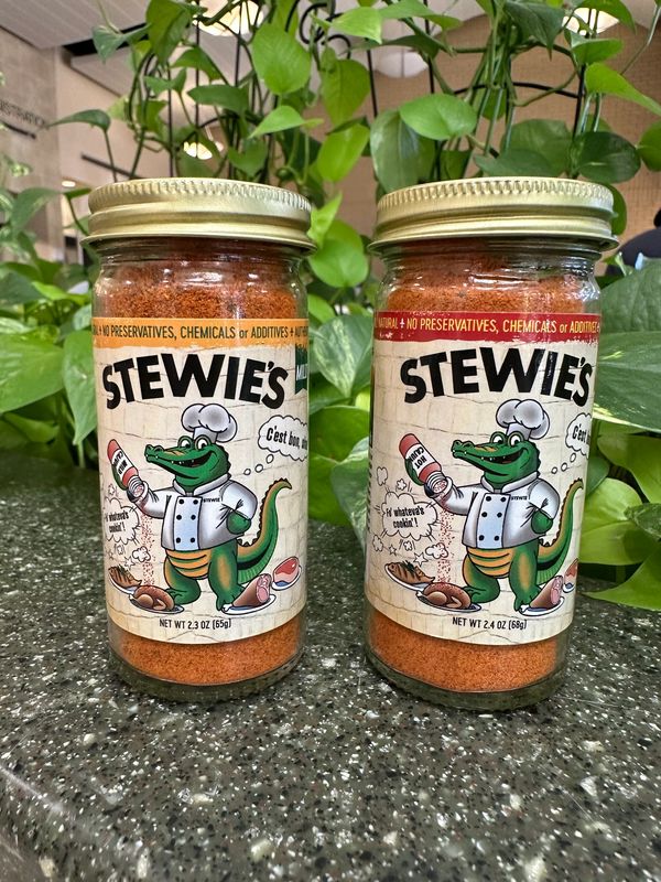 Two jars of Stewie's seasoning with a cartoon alligator chef on labels.
