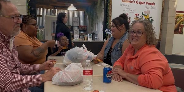 Group of people enjoying food at a casual restaurant table.