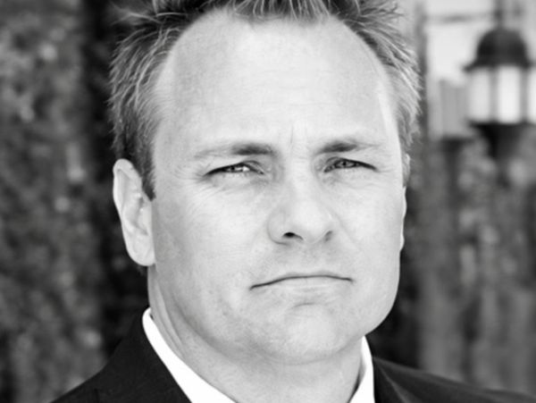 Black and white close-up of a serious man in a suit.