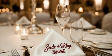 Elegant wedding table setting with personalized napkin for Jade and Rhys.