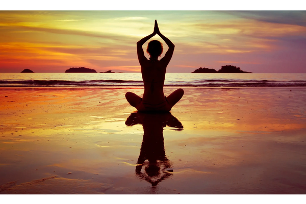 Shadow of a person sitting in a yoga pose at dusk.