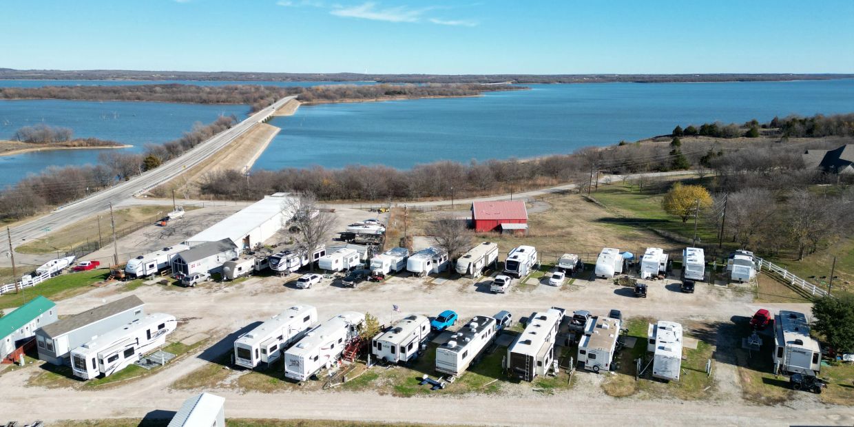 Aerial view of an RV park near a large lake under clear sky.