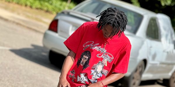 Person wearing a red graphic t-shirt standing outdoors.