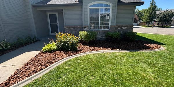 Weeds were removed, the bushes were trimmed back, a new layer of weed barrier was installed, and a f
