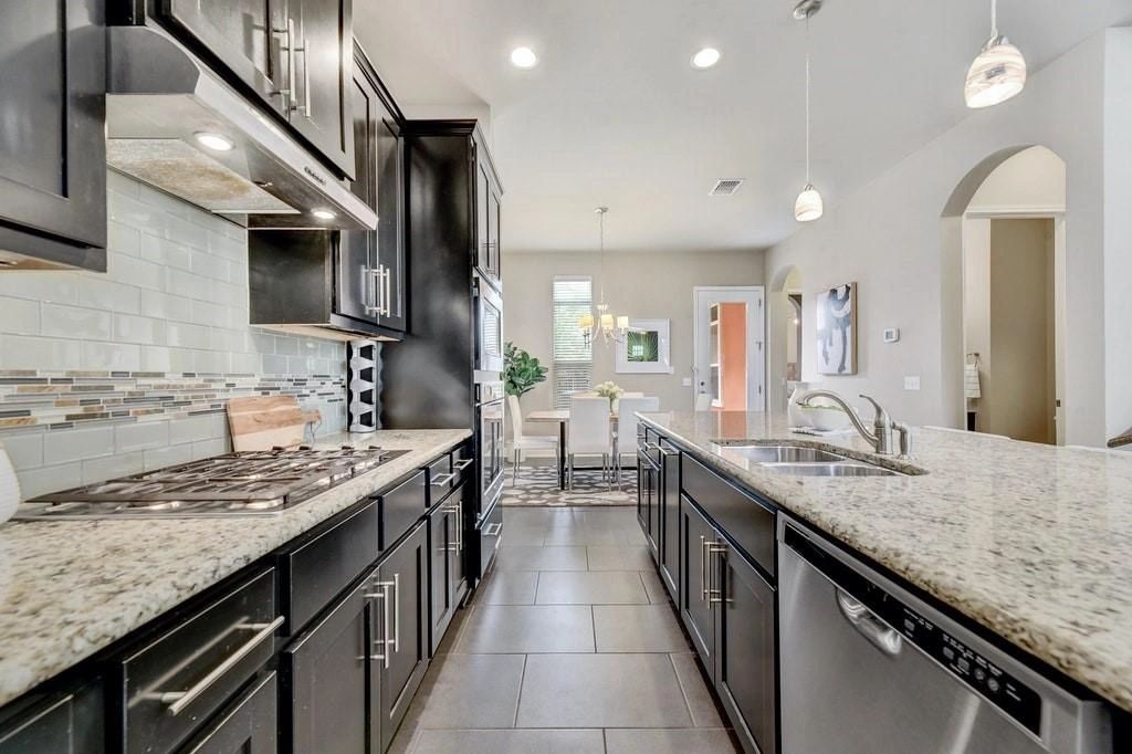 The kitchen features granite countertops and gas stovetop. What a delight, in such a well lit home. 