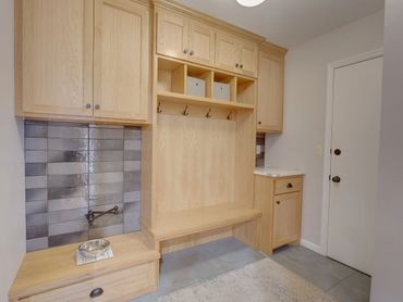Mudroom remodel with grey tile and dog bowl filler