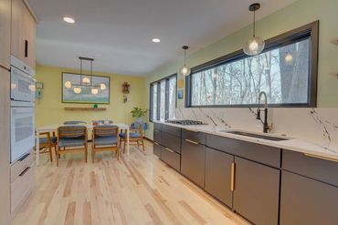 Kitchen Remodel with black and wood cabinets gold hardware black plumbing fixtures