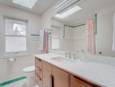 Mid Century Modern bathroom remodel with Cambria Whitney.  Pink and Tourquoise accents.