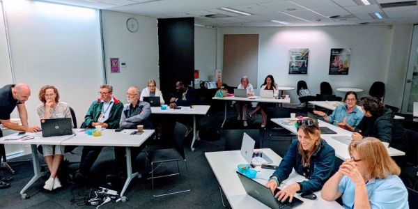Group of people in a meeting room using laptops.