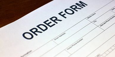Close-up of an order form on a wooden surface.