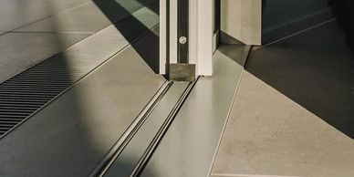 Modern sliding glass door track with sunlight casting shadows.