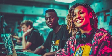 Smiling young woman with headphones, sitting with friends using laptops.