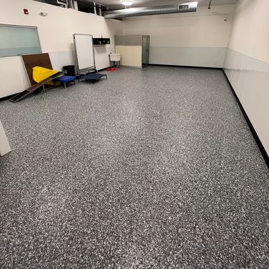 Empty room with speckled floor and minimal furniture.