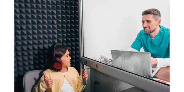 Kız çocuk ve işitme testi yapan adam.