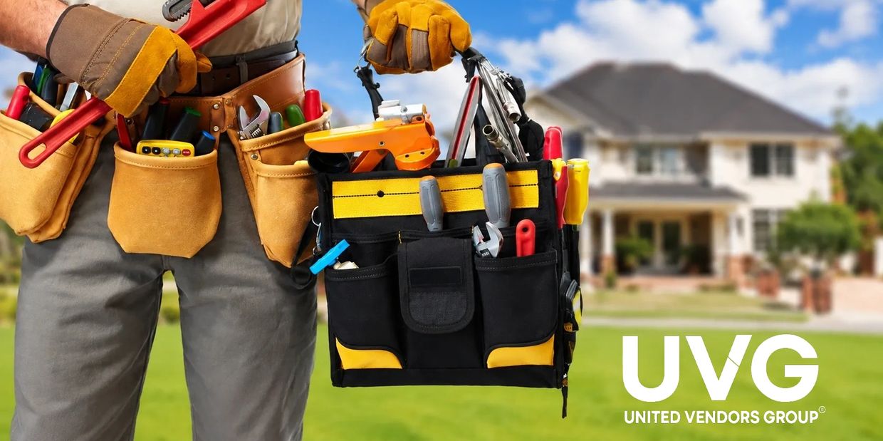 Construction worker holding a tool bag in front of a house.