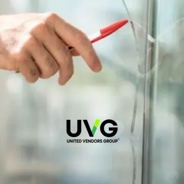 Hand pointing at a crack on a glass window with a pen.