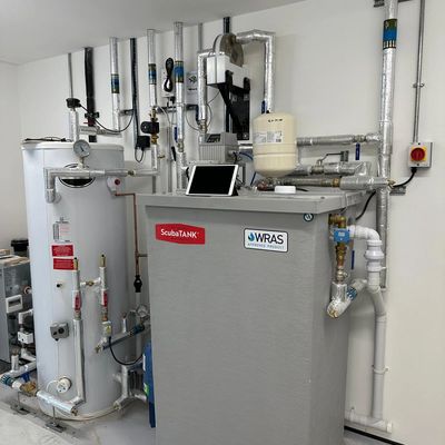 Modern water heating system with insulated pipes and digital controls in a clean utility room.