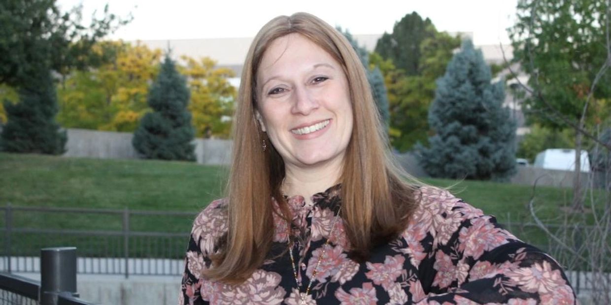 Shevy, warm smile, outdoors.