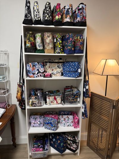 Shelves filled with colorful patterned bags and pouches in a cozy room.