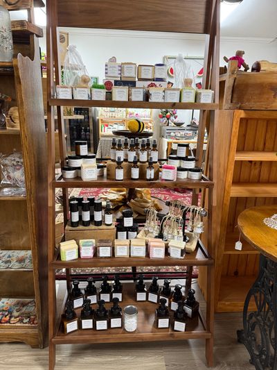 Wooden shelf displaying various handmade soaps, lotions, and personal care products.