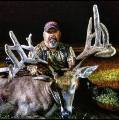 Hunter posing with a large buck deer at night.Free-range hunts, hunting experience, whitetail bucks, buck hunting, deer hunting, bucks, trophy bucks, big bucks