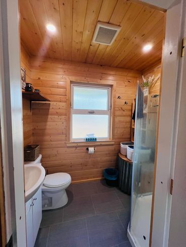 Pine-paneled full bathroom with everything required for comfort.