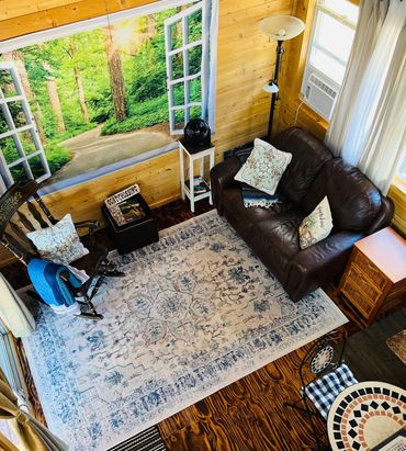 Your cozy loft cabin — Rustic living room with rocking chair, loveseat ♥️ and pine interior.