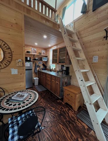 Cabin kitchen and dining area with ladder leading to the loft.