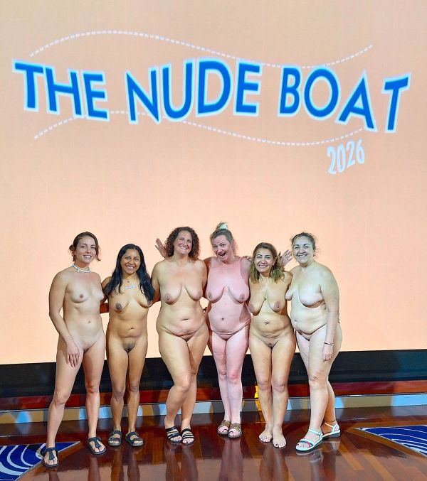 Seis mujeres desnudas posan juntas bajo un cartel que dice "The Nude Boat 2026".