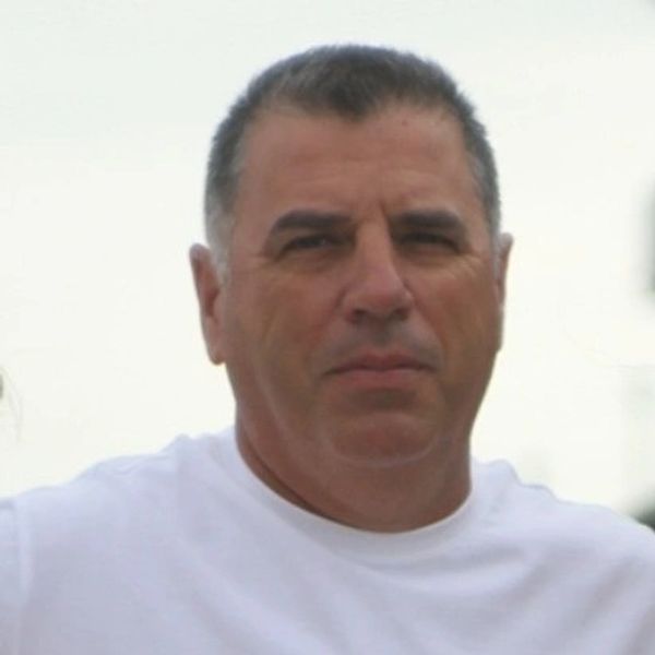 Man in white shirt looking at the camera.
