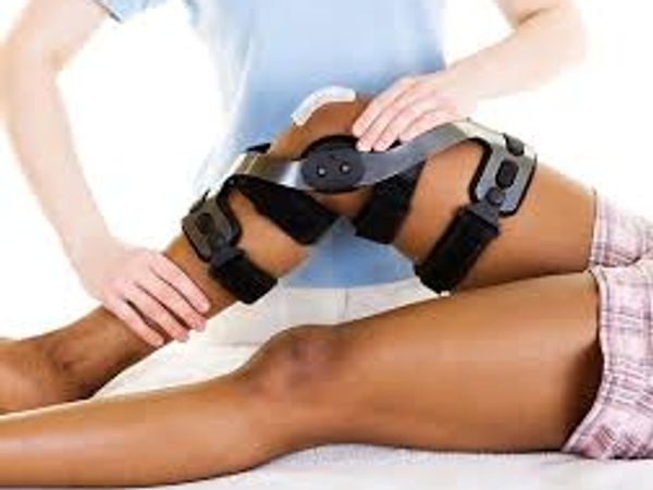 Person assesing injured knee with brace.
