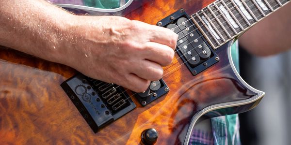 Hand strumming an electric guitar.