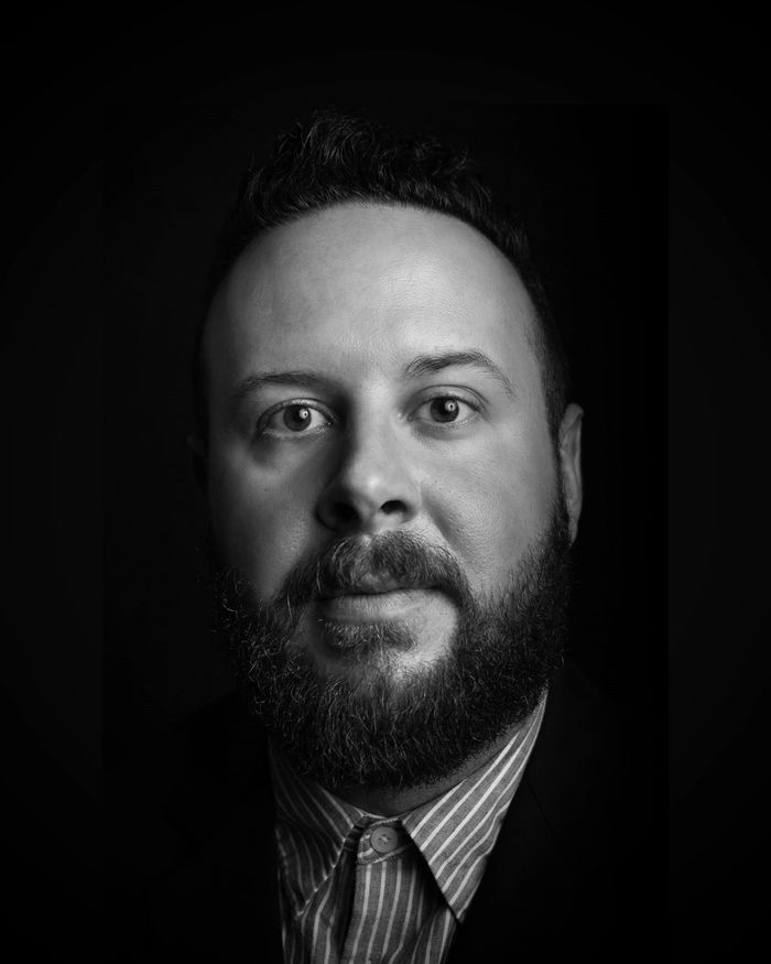 Middle-aged man in white shirt focused on his smartphone.