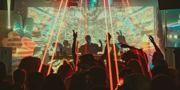Crowd enjoying a DJ performance with colorful lights.