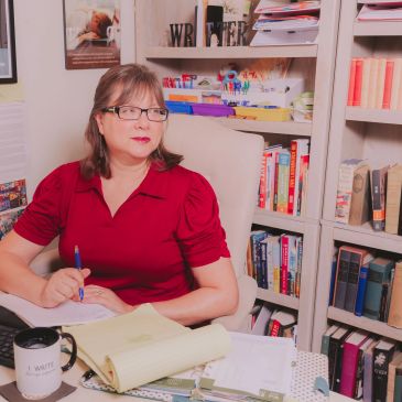 Woman in red shirt writing in a study room.