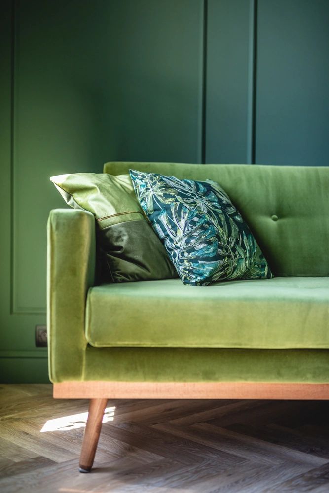 Green couch with decorative pillows