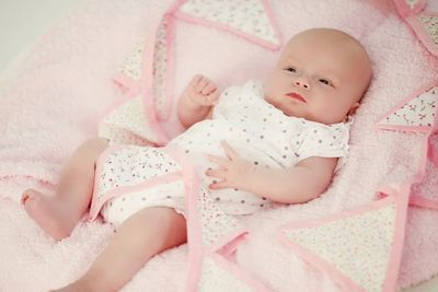 A picture of a baby with a pink blanket and bunting, to represent naming and welcoming ceremonies.