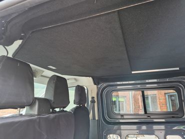 Carpet-lined pop top roof interior in the Ford Transit Custom