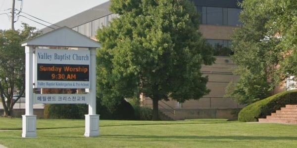 Church sign displaying Sunday worship time and bilingual text.