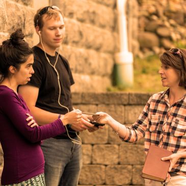 Mature woman handing Bible to young couple.