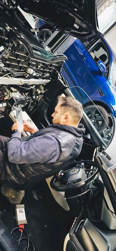 Automotive technician carrying out advanced diagnostics and repairs inside a Lamborghini.