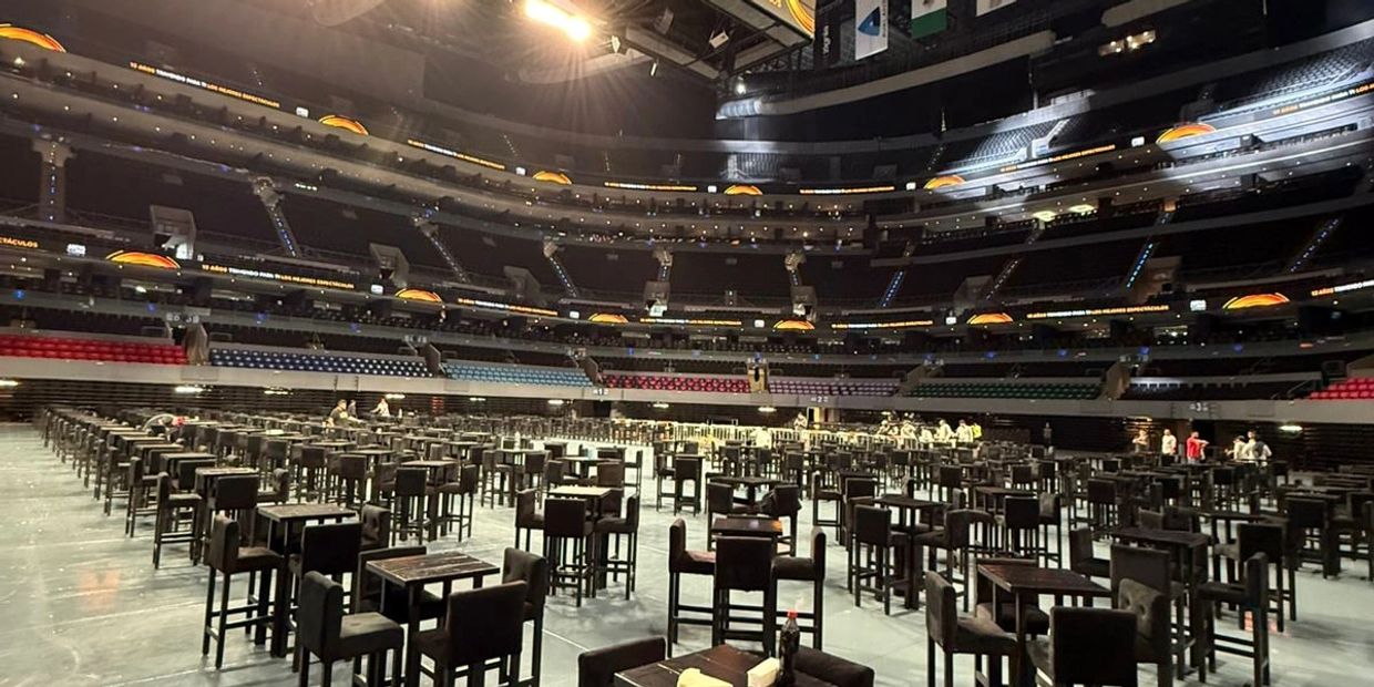 Gran salón con muchas mesas y sillas organizadas.