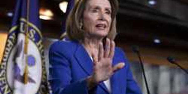 A woman in a blue blazer speaking with a hand gesture.